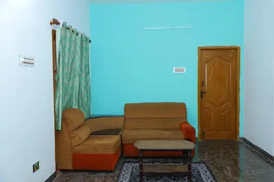 a living room with a couch and a chair at 2Bhk White House Near Isha By Shivalaya Stays in Coimbatore