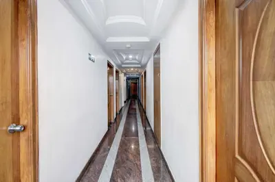 a hallway with a long corridor with wooden doors at Super Townhouse Oak Mysuru City Bus Terminal in Mysore