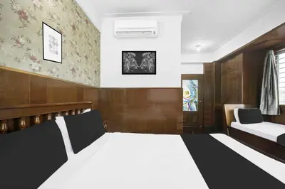 a bedroom with a large bed and a couch at Super Townhouse Oak Mysuru City Bus Terminal in Mysore