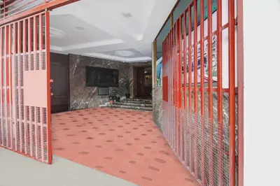 a hallway with red metal doors and a red carpet at Super Townhouse Oak Mysuru City Bus Terminal in Mysore