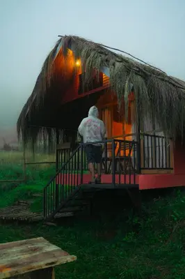 a man walking up the stairs to a thatch hut at Elim Retreat kanthalloor in Kanthalloor