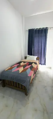a bedroom with a bed and a window at Blue home stay in Kanthalloor