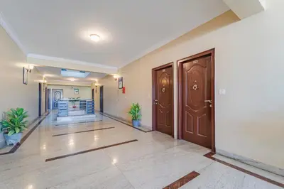 an empty hallway with wooden doors and plants at Treebo Akshaya Palace Inn in Mysore