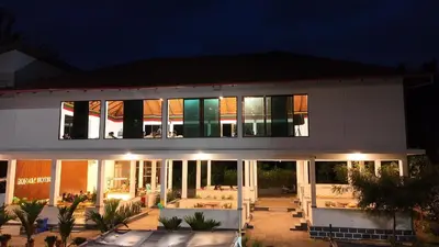 a large white building with a lot of windows at Sonam hotel and restaurant in Kushālnagar