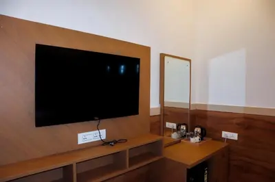 a flat screen tv on a wall in a room at Sonam hotel and restaurant in Kushālnagar