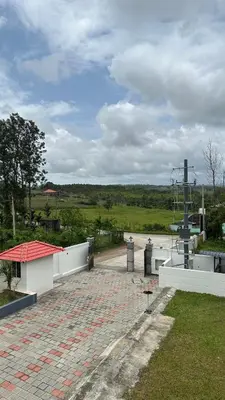 a brick parking lot with a building and a road at Sonam hotel and restaurant in Kushālnagar