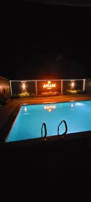 a swimming pool at night with lights in the background at Anam residence in Tāzhekkod