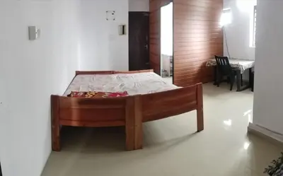 a bedroom with a wooden bed in a room at Aswathy Bhavan Vadakkenchery Near Star auditorium in Vadakkāncheri