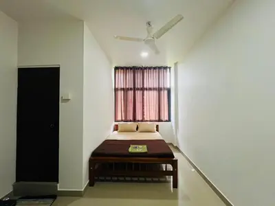 a room with a bed with a window and a table at Mundodan complex in Nilambūr