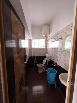a small bathroom with a toilet and a sink at SRB Cottages in Ooty