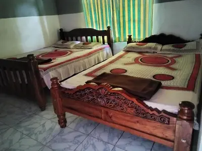 two twin beds in a room with at Lakshmi Vasan Homestay in Madikeri