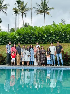 a group of people standing next to a swimming pool at wayanadjunglevillas in Kenichira