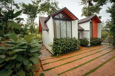 a house with a window and plants in front of it at wayanadjunglevillas in Kenichira