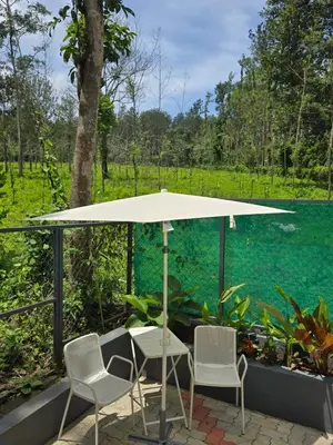 a table and chairs under an umbrella on a patio at Tusker villa in Suntikoppa