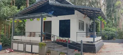 a small house with a porch and stairs to it at Tusker villa in Suntikoppa
