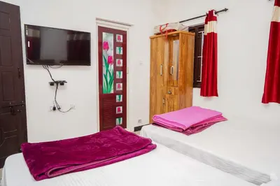 a bedroom with two beds and a tv on the wall at Climate Dull - Homestay Villa in Ketti