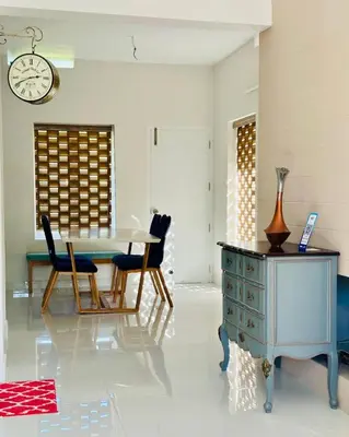 a dining room with a table and chairs and a clock at Zero Degree in Ketti