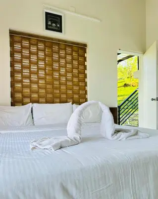 a white bed with a towel forming an arch on it at Zero Degree in Ketti