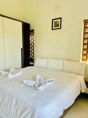 a white bed with two white towels on it at Zero Degree in Ketti