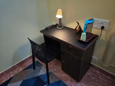 a desk with a lamp and a chair in a room at Tranquil Nest Villa - Wayanad in Kalpetta