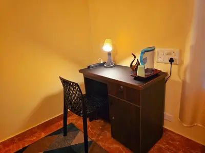 a desk with a lamp and a chair in a room at Tranquil Nest Villa - Wayanad in Kalpetta