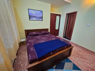 a bedroom with a bed with a blue comforter at Tranquil Nest Villa - Wayanad in Kalpetta