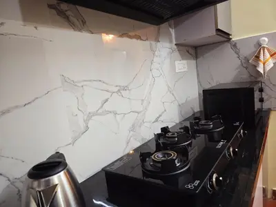a stove top in a kitchen with marble walls at Tranquil Nest Villa - Wayanad in Kalpetta