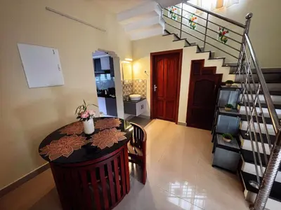a room with a table and a spiral staircase at Tranquil Nest Villa - Wayanad in Kalpetta