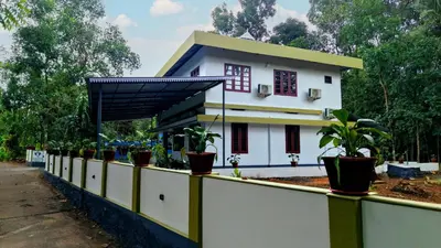 a house with potted plants on a fence at Ganesha Homestay, Cochin, Near Paniyeli Poru Waterfalls in Malayāttūr