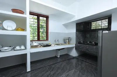 a kitchen with a sink and a refrigerator at Ganesha Homestay, Cochin, Near Paniyeli Poru Waterfalls in Malayāttūr