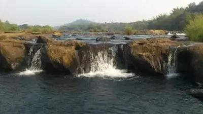 a waterfall in the middle of a body of water at Ganesha Homestay, Cochin, Near Paniyeli Poru Waterfalls in Malayāttūr