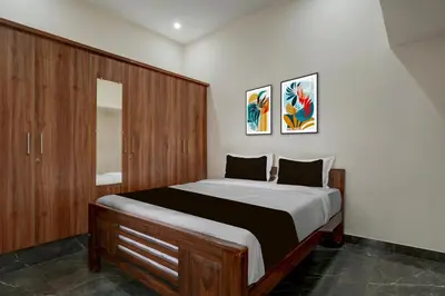 a bedroom with a large bed with wooden cabinets at Hotel O Ambari Residency in Mysore