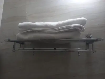 a shelf with white towels on top of it at Maruthamalai Andavar Residency in Coimbatore