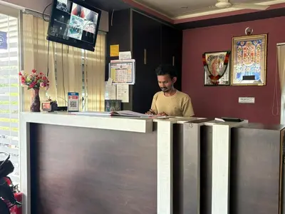 a man sitting at a counter in a restaurant at Parvathi comforts inn in Mysore