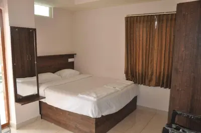 a bedroom with a bed with a mirror on it at Parvathi comforts inn in Mysore