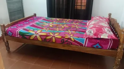 a bed with a colorful blanket on top of it at Suraj Stays Glowing Meadows in Chewarra