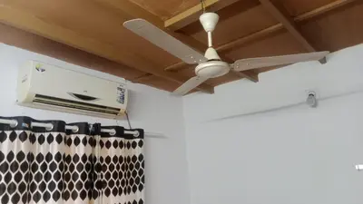 a ceiling fan hanging from a ceiling at Suraj Stays Glowing Meadows in Chewarra