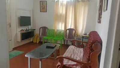 a living room with chairs and a table and a television at Suraj Stays Glowing Meadows in Chewarra