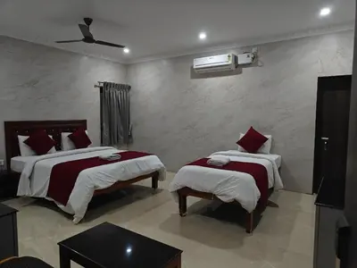 a bedroom with two beds with red pillows at Hotel Grand Palace in Coimbatore