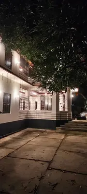 a white building with a tree in front of it at Chunangad in Ottappālam