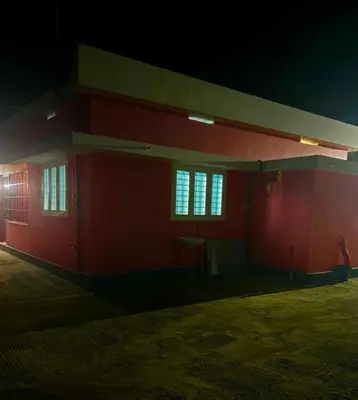 a red building with windows at night at Fog view cottage - Homestay with food and internet in Vythiri