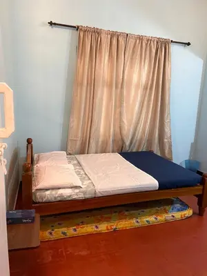 a bedroom with two twin beds and a window at Fog view cottage - Homestay with food and internet in Vythiri