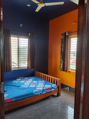 a bedroom with a bed and a ceiling fan at love moon home stay in Mysore
