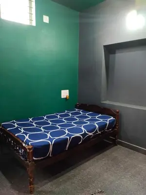 a bed in a room with a green wall at love moon home stay in Mysore