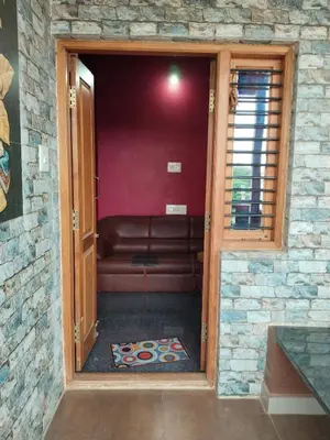 a living room with a couch in a brick wall at love moon home stay in Mysore