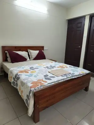 a bed with a quilt on it in a room at City Nature-view apartment in Kozhikode