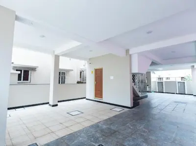 a large room with white walls and a wooden door at Sree Home Stay and Service Apartment Coimbatore in Irugūr