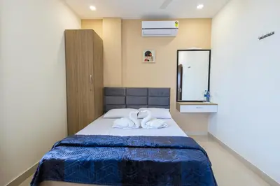 a bedroom with a bed with two towels on it at Sree Home Stay and Service Apartment Coimbatore in Irugūr