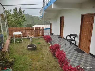 a patio with a bunch of flowers in a yard at diamond hill view cottage in Ooty