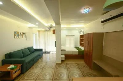 a living room with a couch and a bed at Paradise-Vadanappally Beach Villa for 4-5 adults in Irimbranallūr